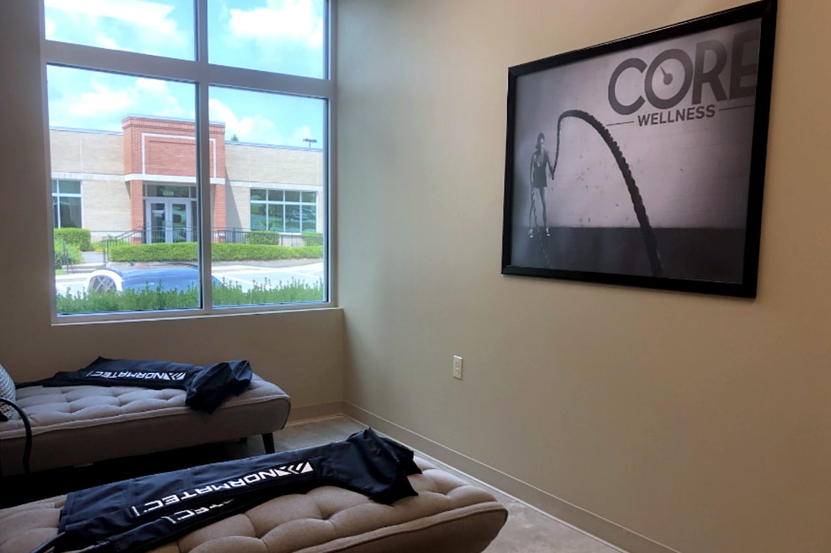 The Core Wellness recovery room, with compression therapy benches beside a window.
